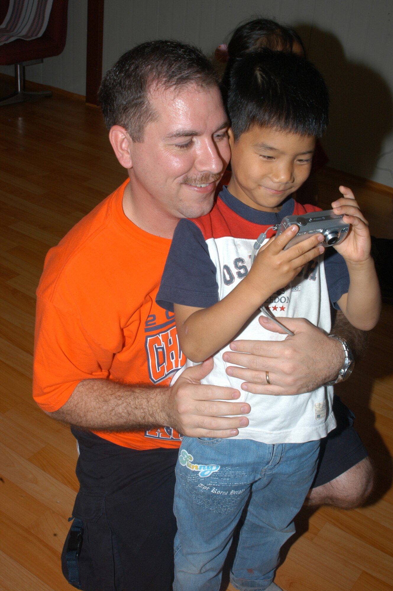 KUNSAN AIR BASE, Republic of Korea -- Master Sgt. Jeff Stokes saves a few memories while posing with a Korean boy after English class. (Air Force photo by Staff Sgt. Becky Nelson)                                