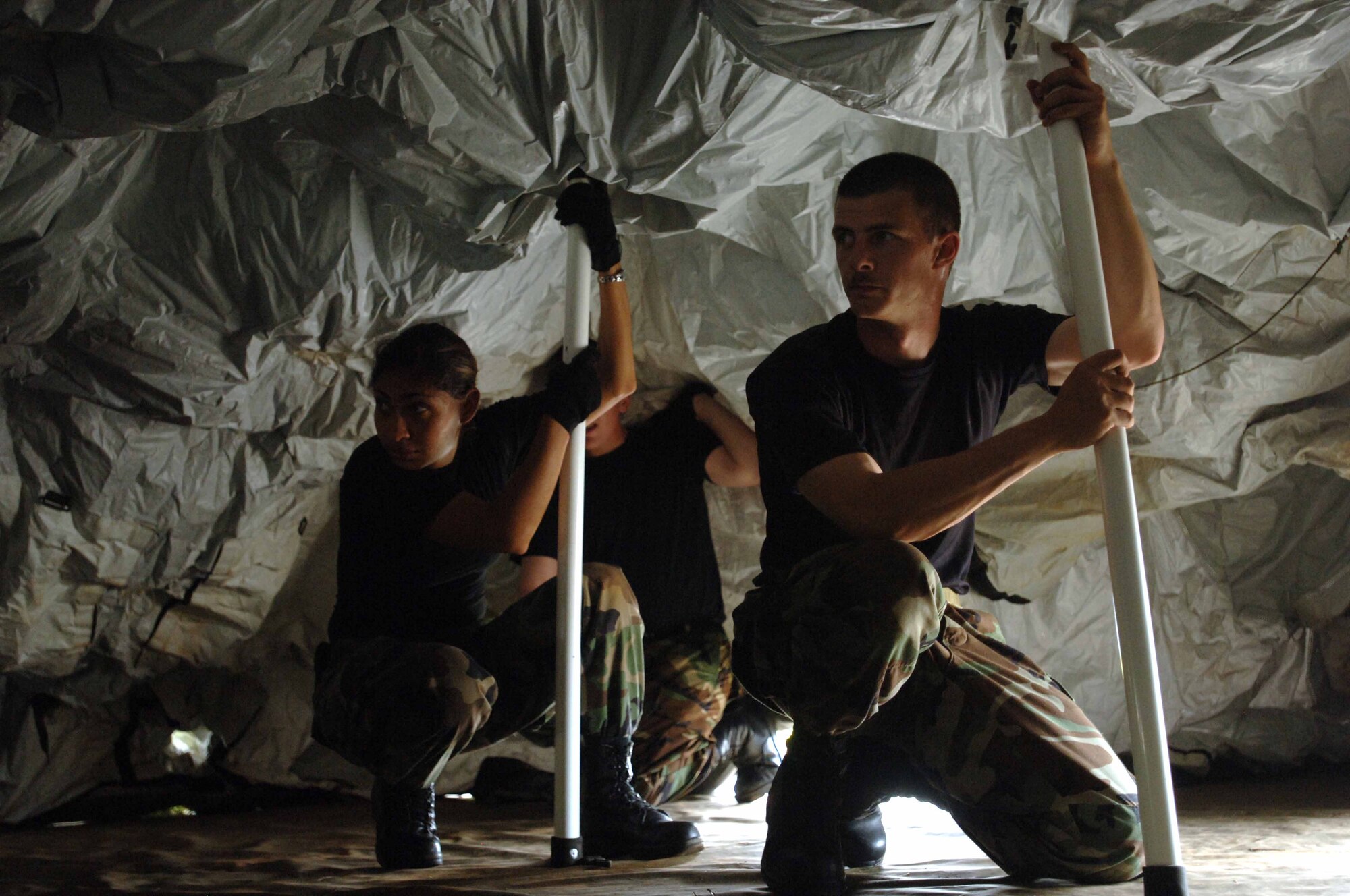 SSgt Rebecca Zaccheo and SSgt Timothy Junak, 682d Air Support Operations Squadron, prepare to erect a Deployable Rapid Assembly Shelter (DRASH) during Operations DYNAMIC WEASEL, June 27, 2006, at McEntire Air National Guard Base, SC. Operation DYNAMIC WEASEL is a multi-aircraft exercise imitating combat operations currently taking place in Southeast Asia. (US Air Force Photo/Staff Sgt. Ashley Brokop)
