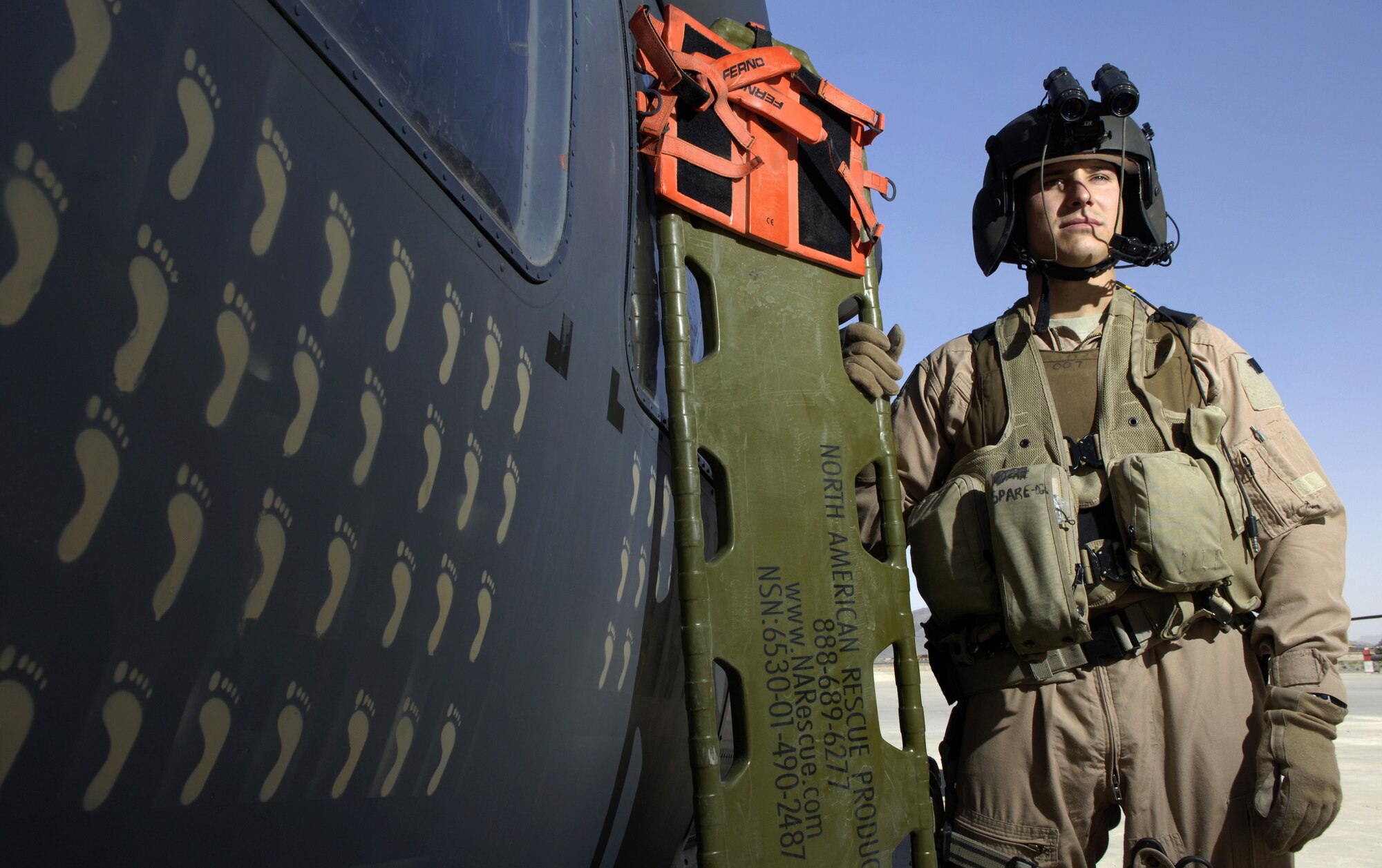 Tech. Sgt. Mark De Corte is an aerospace evacuation technician with the 33rd Expeditionary Rescue Squadron in Kandahar, Afghanistan. The tan footprints on the HH-60 Pavehawk helicopter represent each of the saves the squadron has made. (U.S. Air Force photo/Senior Airman Brian Ferguson) 