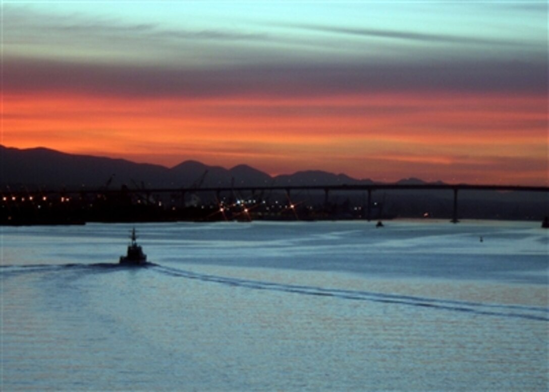 The amphibious assault ship USS Peleliu enters San Diego Harbor at sunrise Jan. 26, 2006, accompanied by harbor police. Peleliu and Expeditionary Strike Group 3 were under way off the coast of Southern California conducting their Joint Task Force Exercise.