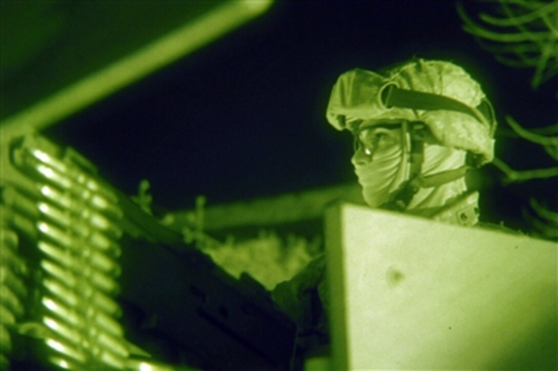 U.S. Army Pfc. Peter Medellin, with Battery B, 4th Battalion, 320th Field Artillery Regiment, 4th Brigade Combat Team, 101st Airborne Division, provides security with a .50-caliber machine gun during a target raid operation in the Zafaraniyah district of Baghdad, Iraq, Jan. 31, 2006.