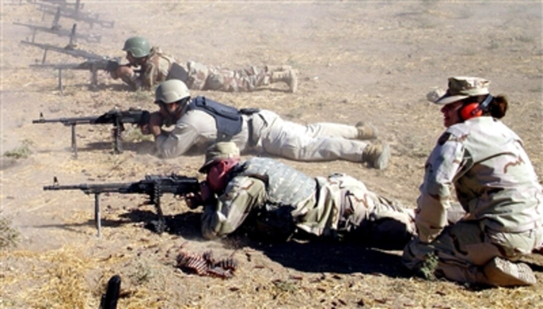 Capt. LeeAnn Roberts instructs Iraqi trainees and a coalition soldier on proper firing techniques at the Al Kasik Training Base firing range, Iraq, Jan. 30, 2006. She is the first female coalition military assistance training team instructor assigned to the base, and the only female out of 8,000 assigned personnel.