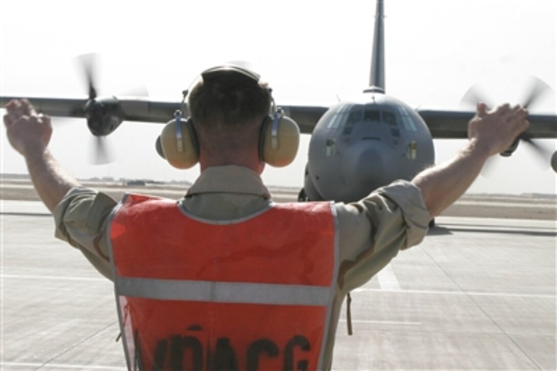 A U.S. servicemember prepares an Iraqi air force C-130, transporting Iraqi security force recruits, for takeoff on the runway in Al Asad, Iraq, Dec. 21, 2005. The recruits are headed to Al Kut, Iraq, for basic training. 