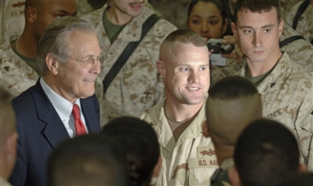 U.S. Defense Secretary Donald H. Rumsfeld poses for photos and greets Marines and sailors stationed at Camp Fallujah, Iraq on Dec. 23, 2005. Rumsfeld was in the country visiting with the troops, thanking them for their service and wishing them a happy holiday season. 