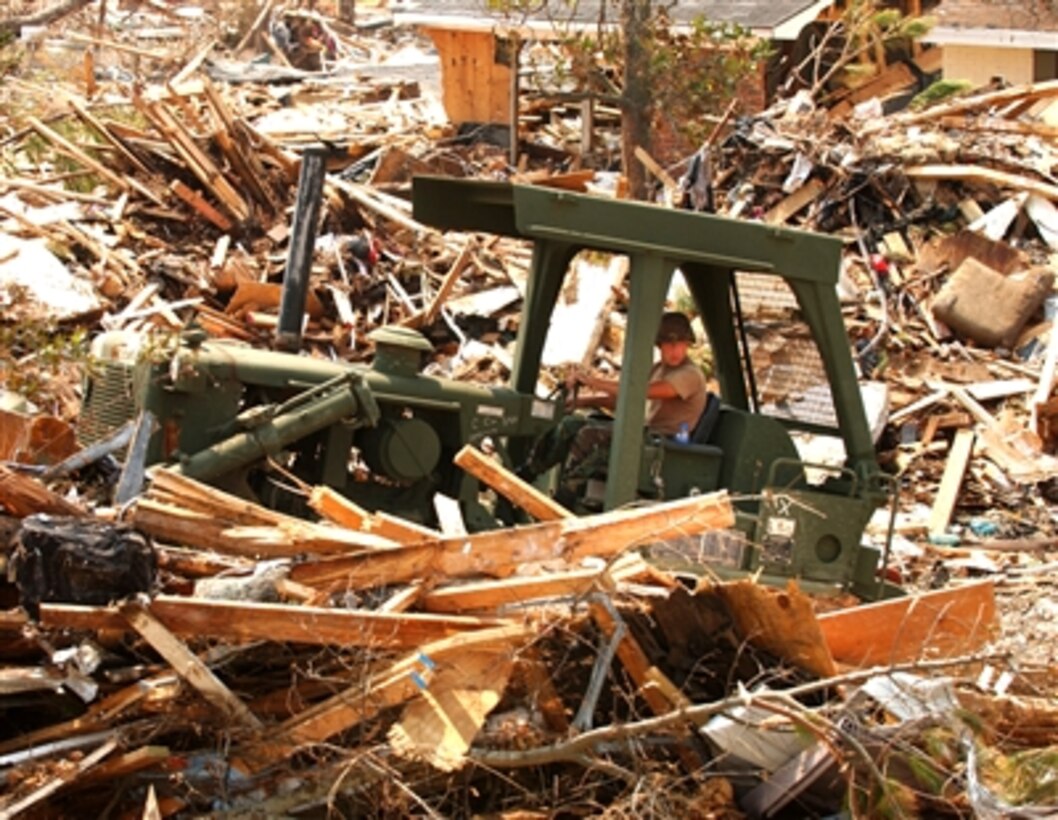 U.S. Army Spc. James Meidl, a heavy equipment operator from the 890th Engineering Battalion, Mississippi Army National Guard, clears debris left by Hurricane Katrina on roads in Pass Christian, Miss., on Sept. 7, 2005. 