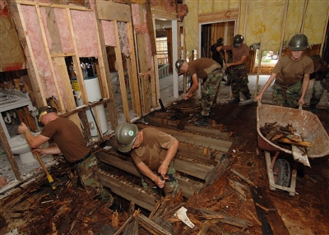 U.S. Navy Seabees assigned to Naval Mobile Construction Battalion 133, tear and remove plywood from the sub-floor, as they take part in restoring Hope Haven, a child abuse shelter in Waveland, Miss., in support of Hurricane Katrina Relief efforts on Sept. 12, 2005.