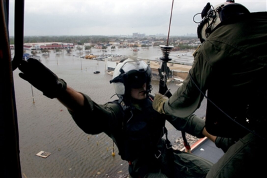 U.S. Navy Petty Officer 2nd Class Scott Wilson, a search and rescue swimmer assigned to Helicopter Anti-Submarine Squadron Light 48, prepares to be lowered during a search and rescue mission over New Orleans, Sept. 24, 2005.
