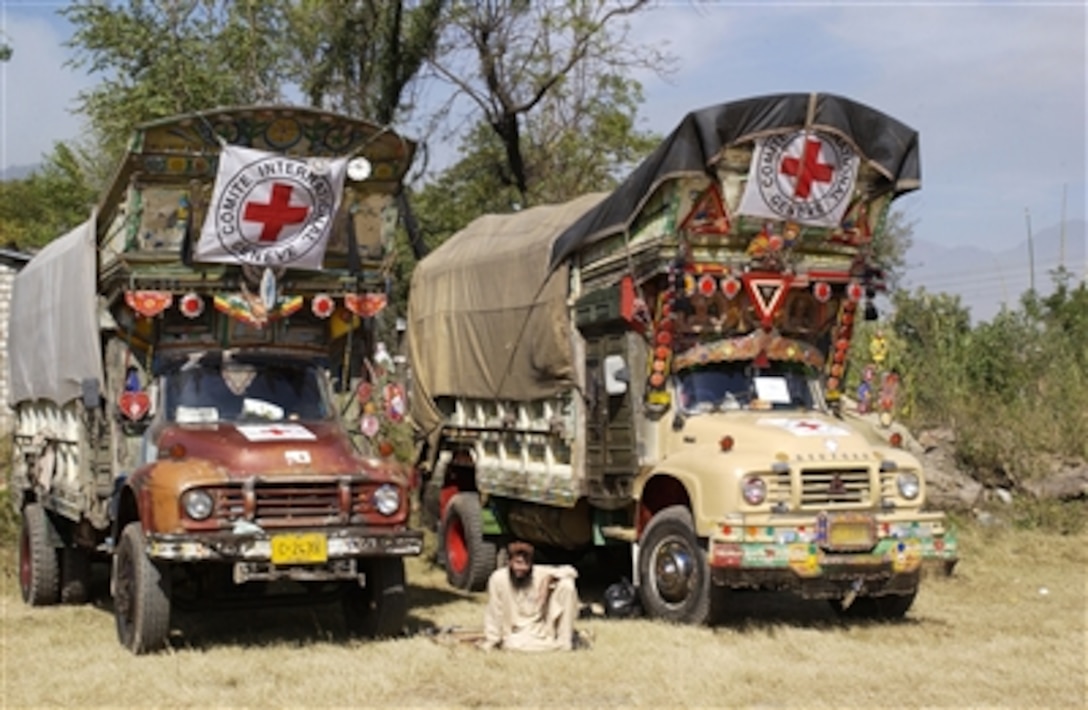 Pakistani rests between two supply trucks while awaiting guidance for his next delivery of goods at a makeshift helicopter airfield in Muzaffarbad, Pakistan, Oct. 28, 2005. The Defense Department is delivering disaster relief supplies and services to Pakistan and parts of India and Afghanistan following a devastating earthquake. 