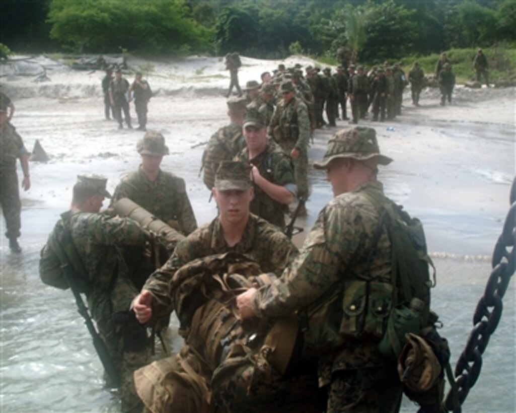 Marines of the 31st Marine Expeditionary Unit offload supplies from a Landing Craft, Utility onto a beach on the island of Luzon in the Republic of the Philippines, Oct. 22, 2005, during Amphibious Landing Exercise 06.