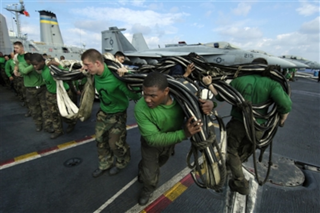 Sailors haul an emergency landing barricade net across the flight deck during a replenishment at sea between the USS Kitty Hawk and the USNS Walter S. Diehl in the Pacific Ocean, Oct. 29, 2005.  