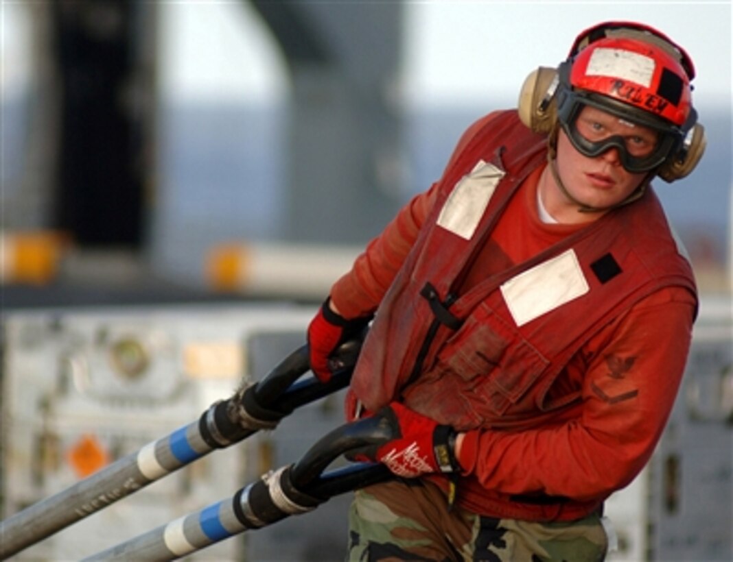 A Sailor assigned to the weapons department aboard the USS Harry S. Truman pulls two replenishment slings across the flight deck during an ammunition offload operation. The Truman is currently underway off the coast of the Eastern United States conducting replenishments at sea and weapons offload operations with other Navy ships.  
