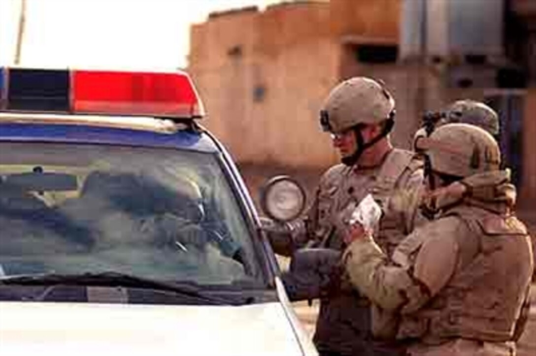 U.S. Army Lt. Col. Gregory Reilly, 3rd Armored Cavalry Regiment, speaks with Iraqi police during cordon and search operations in Bi'aj, Iraq, Jan. 24, 2006. 