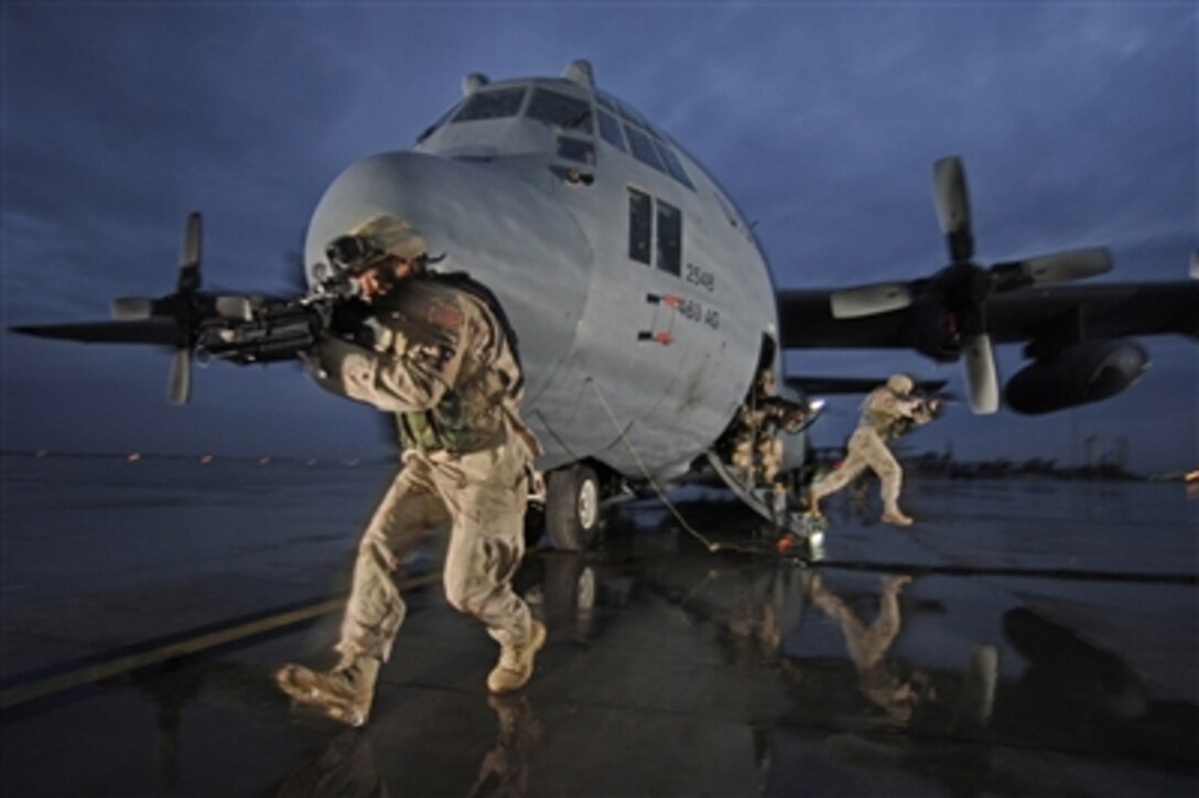 From left, U.S. Air Force Staff Sgt. Tony Rivera and Senior Airmen Jason Bauer and Darryll Morley, all with the 332nd Expeditionary Security Forces Squadron, provide aircraft security for a C-130 Hercules aircraft from the 463rd Airlift Group at Balad AirBase, Iraq, Jan. 25, 2006. 