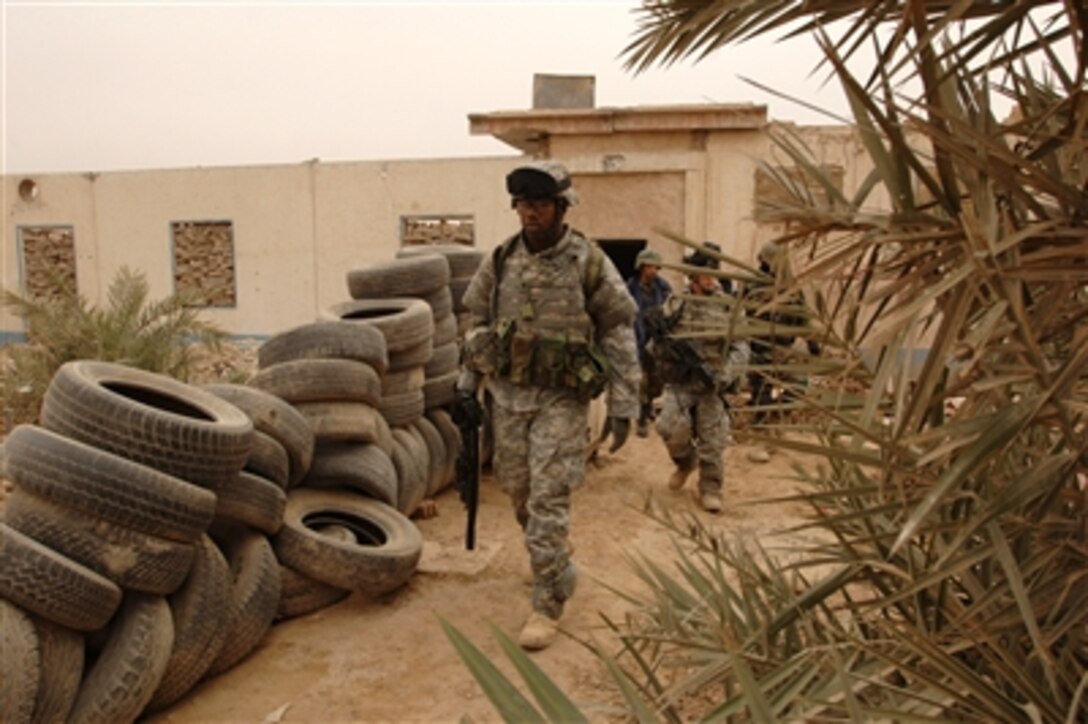 U.S. Army soldiers from the 101st Airborne Division and Iraqi police officers exit a house after searching for possible weapons caches in Baghdad, Iraq, Jan. 23, 2006. 
