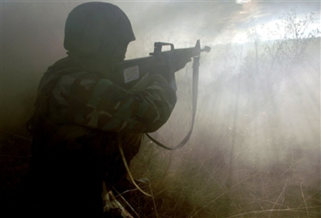 A U.S. Air Force airman aims into the fog during a combat skills training course at Fairchild Air Force Base, Wash., Nov. 10, 2005. Fairchild is among the Air Mobility Command bases that have started conducting combat skills training.