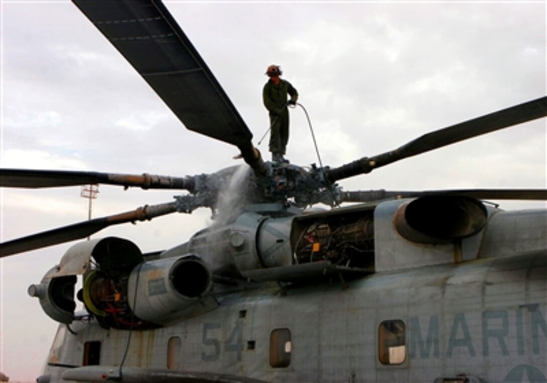 U.S. Marine Corps Lance Cpl. Anthony D. Schieman, assigned to Marine Heavy Lift Squadron 466, pressure washes a CH-53E helicopter in Al Asad, Iraq on Nov. 16, 2005. The squadron is deployed in support of Operation Iraqi Freedom.