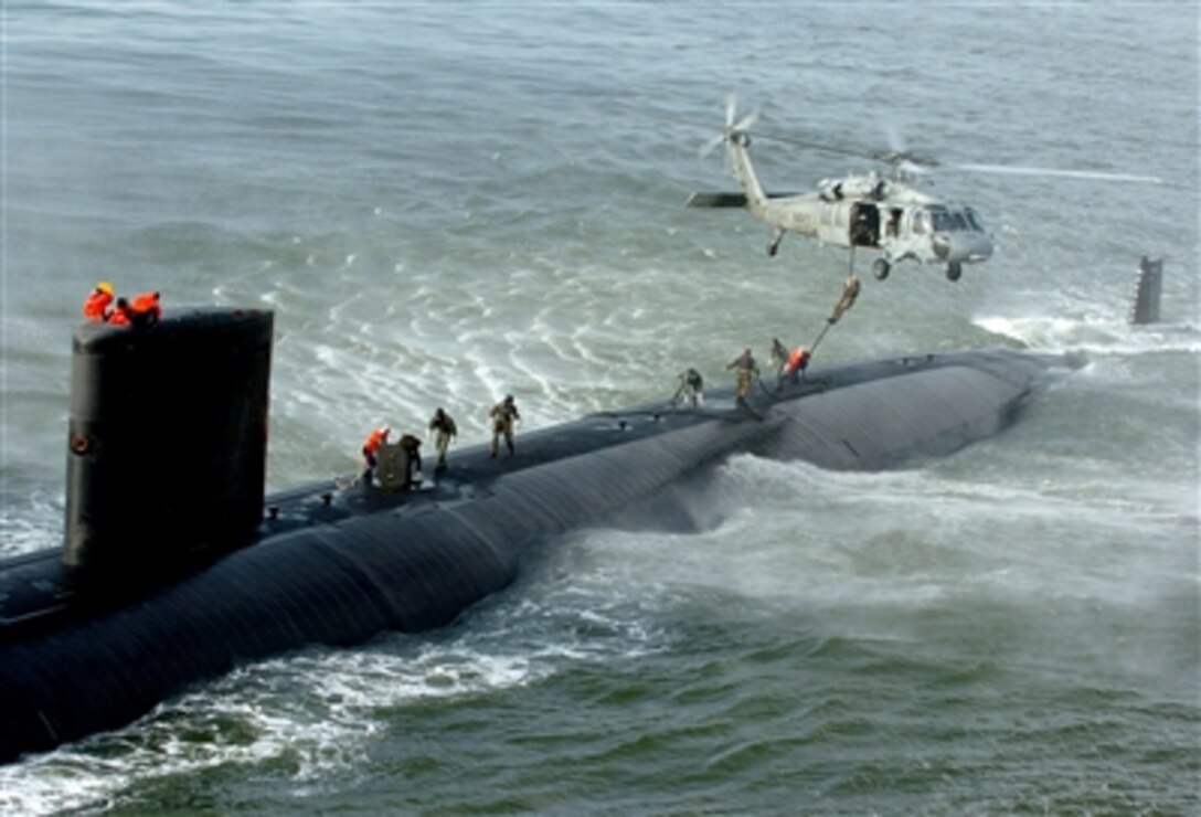 A SEAL delivery vehicle team performs a fast-roping exercise from a MH-60S Seahawk helicopter to the topside of Los Angeles-class fast attack submarine USS Toledo off the Atlantic coast, Jan. 17, 2006. The mission of the team includes clandestine insertion of SEALs, ordnance delivery, reconnaissance, and locating and the recovery of objects.