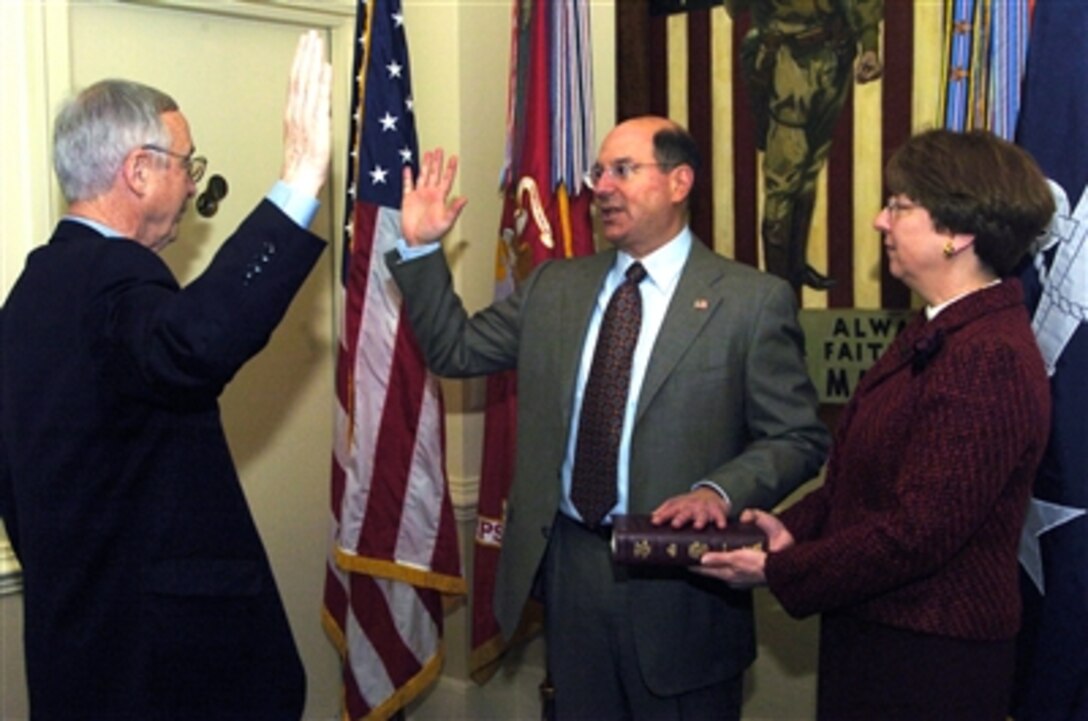 The Honorable Dr. Donald C. Winter (center) takes the oath of office as the 74th Secretary of the Navy at the Pentagon, Jan. 3, 2006. Deputy Defense Secretary Gordon England administered the oath while Winter's wife, Linda, looked on.