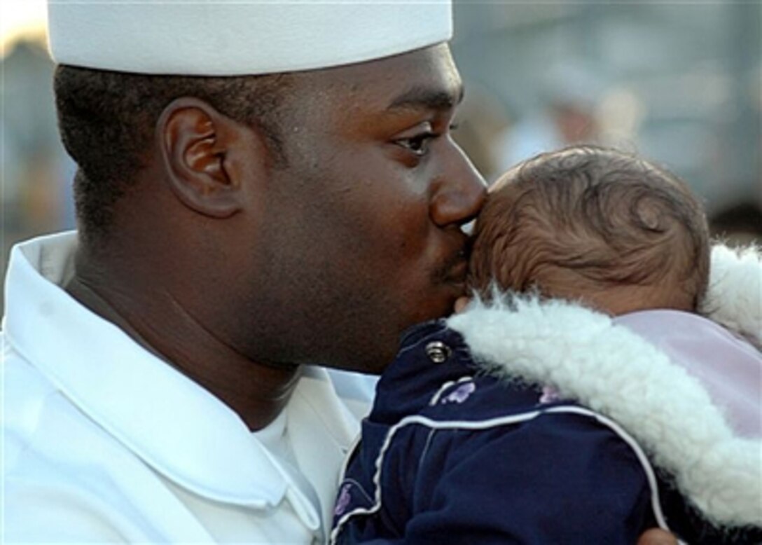 .S. Navy Petty Officer 3rd Class Leroy Quinn kisses his son before departing Pearl Harbor, Hawaii, Jan. 5, 2006, aboard the guided missile destroyer USS Chung-Hoon for a maiden five-month deployment in support of the global war on terrorism. The Chung-Hoon will conduct expanded maritime interception operations deterring, delaying and disrupting the movement of terrorists at sea.