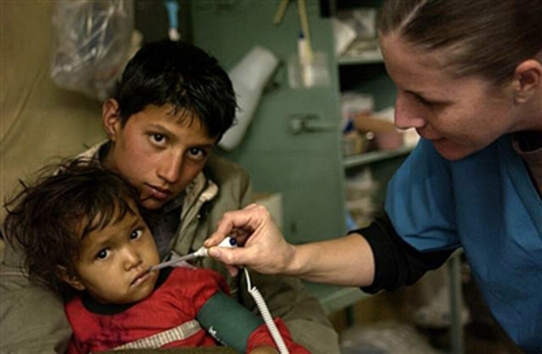 U.S. Army 1st Lt. Tanya Luckado from the 212th Mobile Army Surgical Hospital measures a young patient's body temperature during a blood transfusion at the MASH in Muzaffarabad, Pakistan, Jan. 7, 2006. The U.S. military is participating in the Pakistani-led relief operation designed to aid victims of the devastating earthquake that struck the region Oct. 8, 2005.