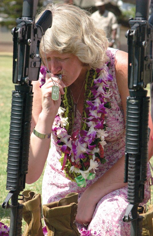Joyce Bertolino of Hampstead, N.H., wept as she kisses the dog tags of her late son, Pfc. Matthew Bertolinoi. Bertolino, who was attached to 1st Battalion, 3rd Marines and killed in Afghanistan on Feb. 9,  was one of four servicemembers who were rememberd at a memorial service June 29.