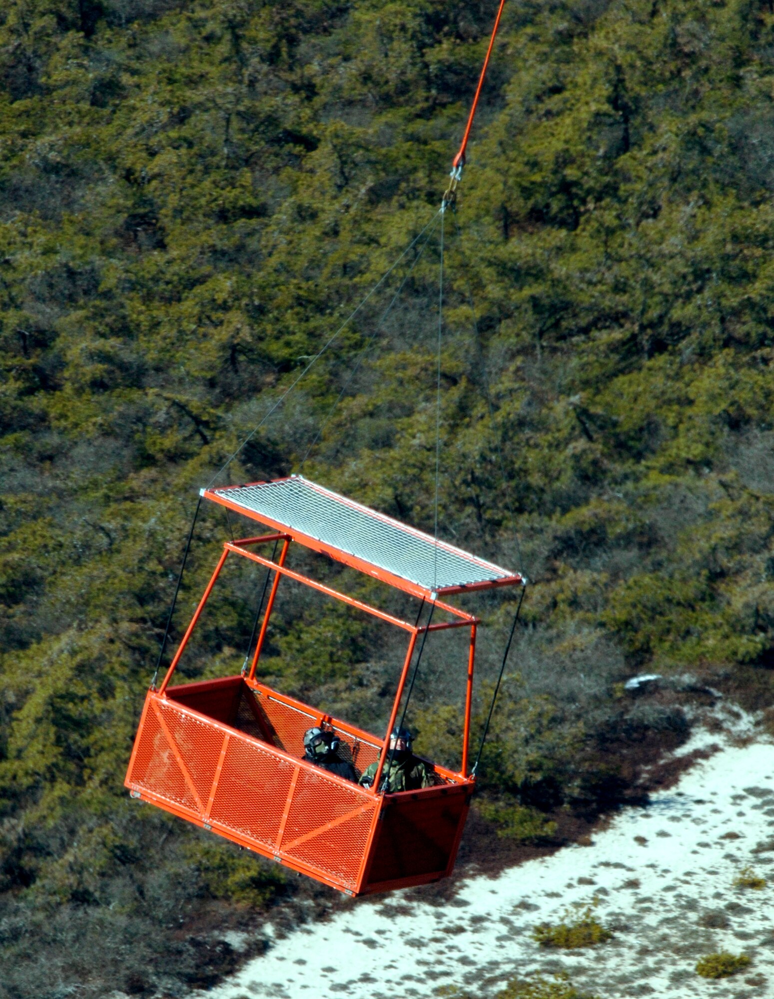 An HH-60 Pave Hawk helicopter carries a rescue basket during certification training at Westhampton Beach, N.Y., Tuesday, Feb. 28, 2006. Volunteers from the 106th Rescue Wing at Francis S. Gabreski Field, N.Y., tested the basket so it can be certified for use in rescuing people. It was the first time humans were used in the testing. (U.S. Air Force photo/Master Sgt. Jack Braden)