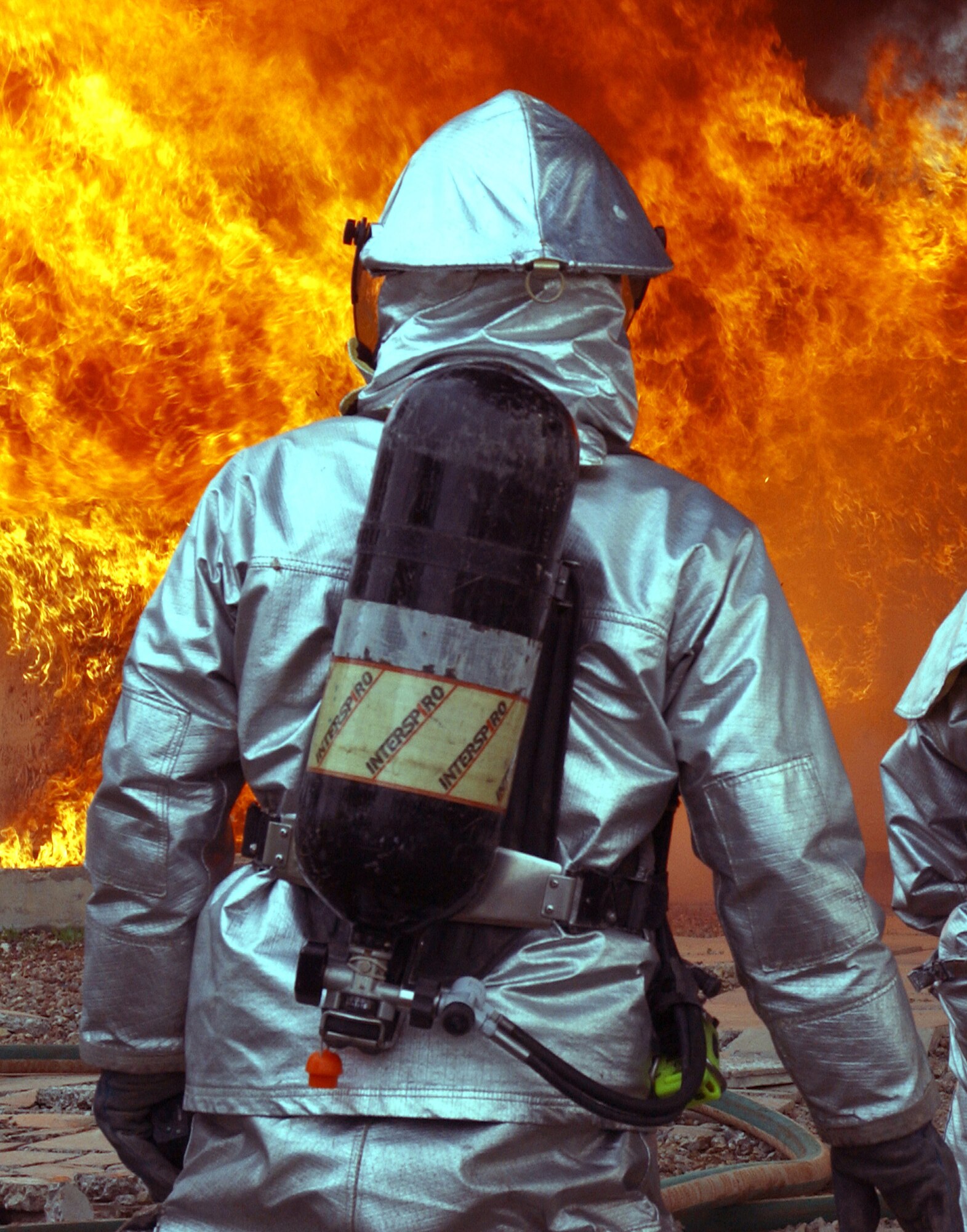 A firefighter with the 332nd Expeditionary Civil Engineer Squadron keeps a watchful eye on a structural fire at Balad Air Base, Iraq, Thursday, Feb. 16, 2006. The fire was set as part of a live-fire training exercise for the fire department. (U.S. Air Force photo/Tech Sgt. Steve Horton)