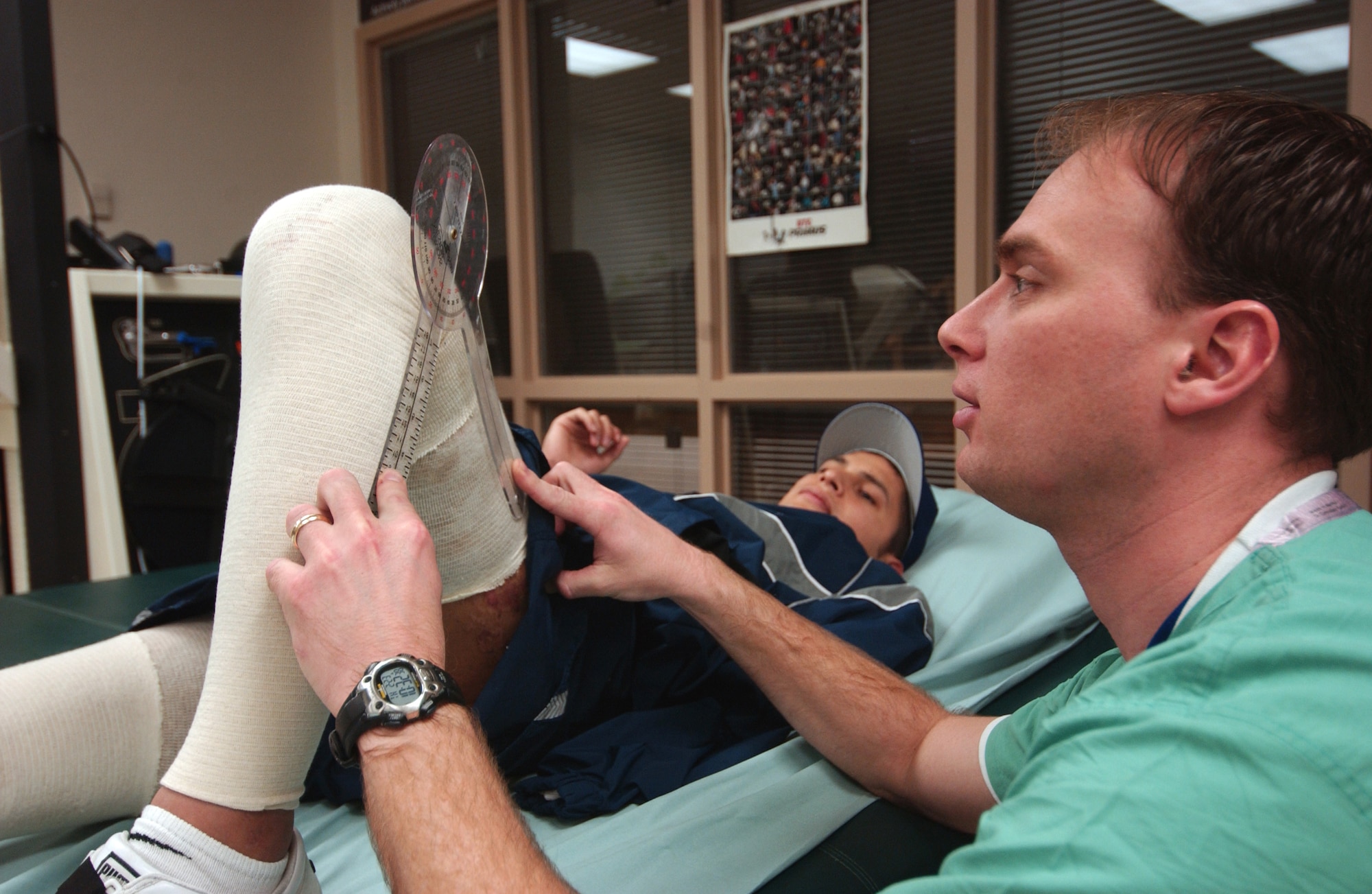 Physical therapist Scott Dewey checks the range of motion of Senior Airman Dan Acosta's legs during a therapy session Thursday, Feb. 23, 2006, at the burn rehabilitation center at Brooke Army Medical Center in San Antonio. (U.S. Air Force photo/Steve White) 