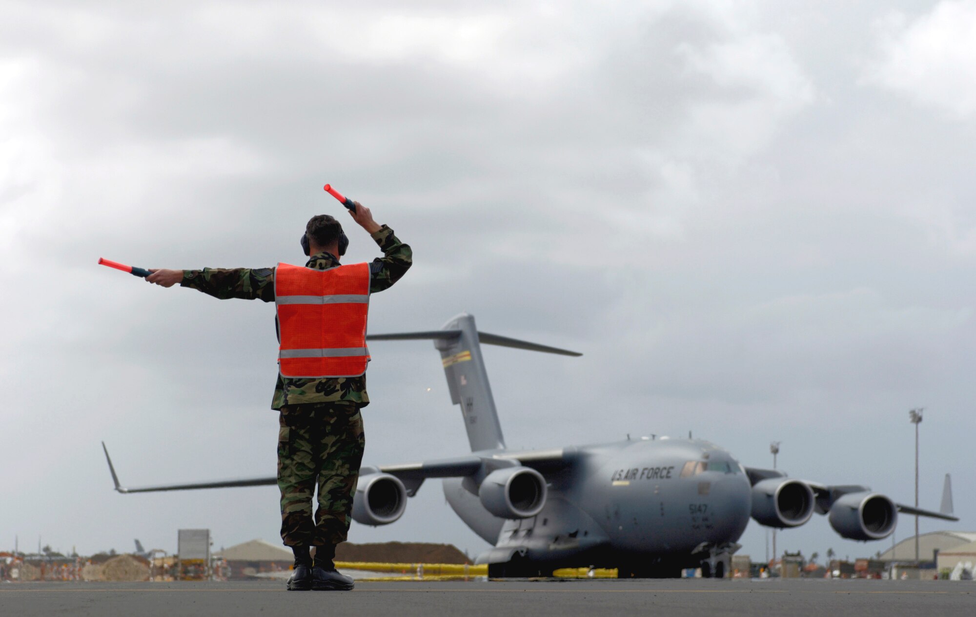 Staff Sgt. Wesley Clark marshals a C-17 Globemaster III into its parking spot at Hickam Air Force Base, Hawaii, Tuesday, Feb. 28, 2006.  Sergeant Clark is a crew chief with the 15th Maintenance Group, which is a combined active duty and Air National Guard maintenance group. (U.S. Air Force photo/Tech. Sgt. Shane A. Cuomo)