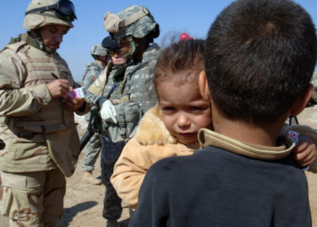 Soldiers from the U.S. Army's 66th Armor Regiment, 1st Brigade, 4th Infantry Division, prepare medicine for local children during a community health outreach program in Rushadah, Iraq, on Feb. 23, 2006. 