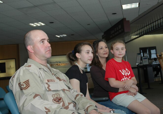 Tech. Sgt. Joseph Moorer, an Air Force reservist assigned to the 38th Aerial Port Squadron, Charleston AFB, S.C., waits to leave for an extended deployment with his wife Tina and daughters Brittany (center) and Elizabeth (right) at the Charleston International Airport.  (Photo by 1st Lt. Wayne Capps, USAFR)