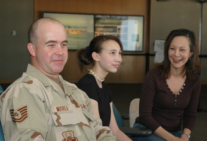 Tech. Sgt. Joseph Moorer, an Air Force reservist assigned to the 38th Aerial Port Squadron, Charleston AFB, S.C., waits to leave for an extended deployment with his wife Tina and daughter Brittany at the Charleston International Airport. (Photo by 1st Lt. Wayne Capps, USAFR)