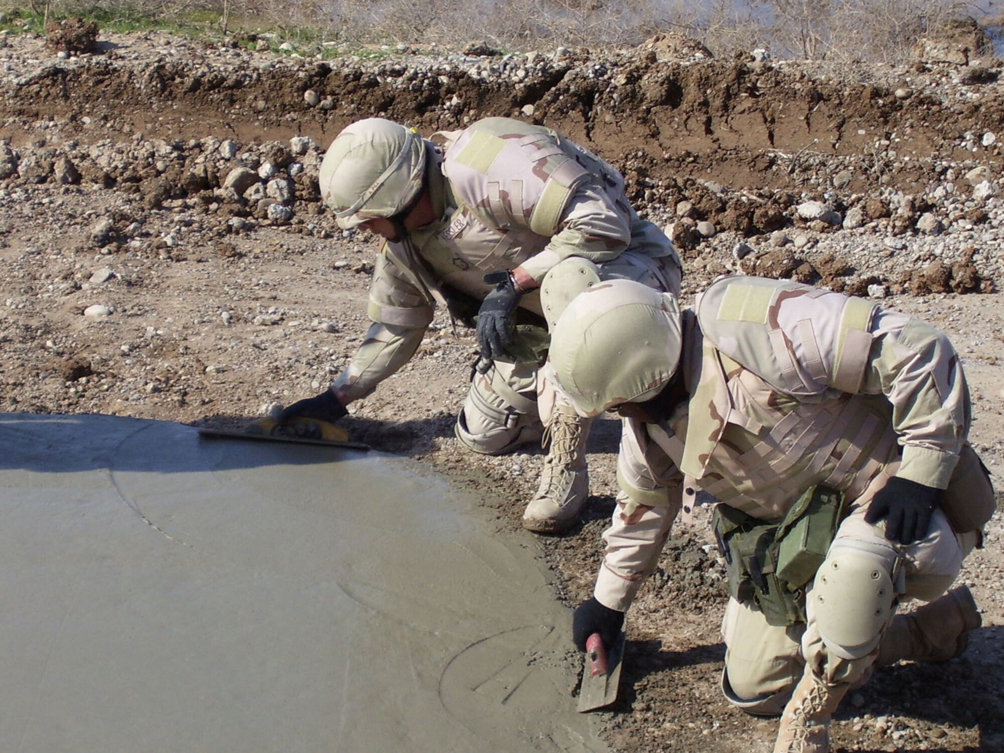 Master Sgt. Kirk Kessler and Senior Airman Ryan Whorley prepare a finished surface on a crater used multiple times by insurgents on a route on the outskirts of Kirkuk, Iraq. They are with Detachment 10 of the 732nd Expeditionary Civil Engineer Squadron and are assisting the Army in making convoy and patrol routes safe. (Courtesy photo) 
