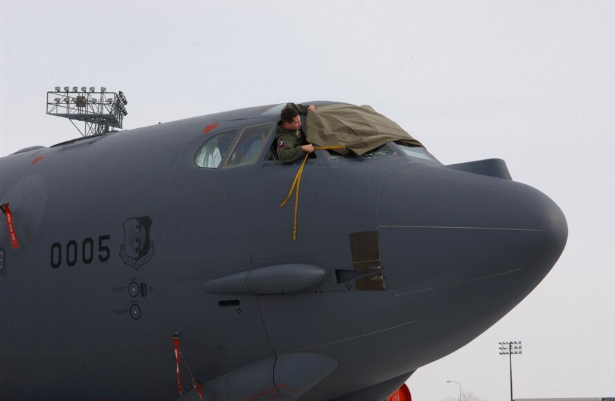 An Airman from the 23rd Bomb Squadron removes a window cover on a B-52H Stratofortress during an alert generation exercise at Minot Air Force, Base, N.D., Tuesday, Feb. 28, 2006.  The exercise tested cruise missile loading and aircrew response procedures.  (U.S. Air Force photo/Staff Sgt. Jocelyn Rich)                                       