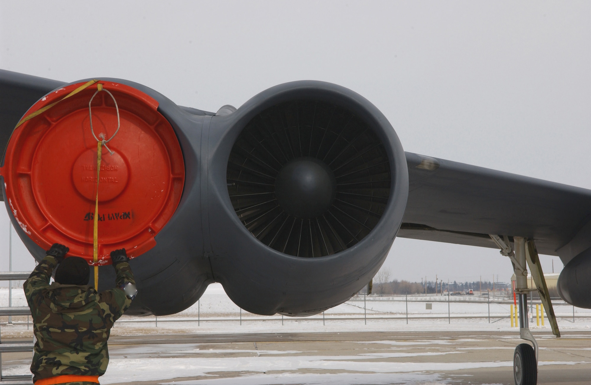 Airman 1st Class Michael Schaff secures a B-52H Stratofortress engine intake cover during an alert generation exercise at Minot Air Force Base, N.D., Tuesday, Feb. 28, 2006.  The exercise tested cruise missile loading and aircrew response procedures. Airman Schaff is with the 5th Aircraft Maintenance Squadron. (U.S. Air Force photo/Staff Sgt. Jocelyn Rich)  