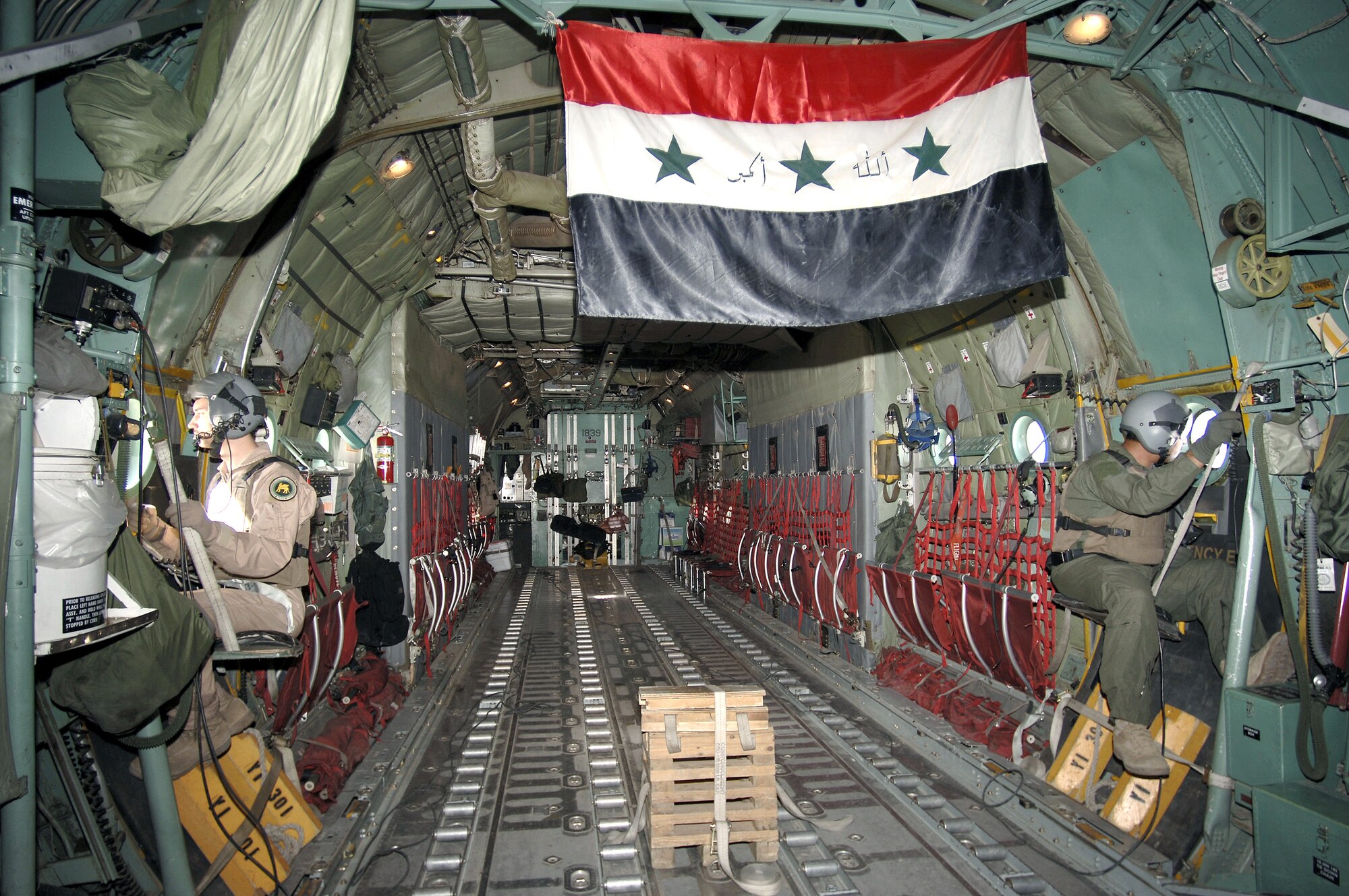 An Iraqi crewmember and Staff Sgt. Dominic Pecoraro (left) watch carefully for enemy weapons fire from their C-130E Hercules.  If necessary the loadmasters have flares they can fire away from the aircraft to distract various weapons. The Iraqi loadmaster is assigned to the 23rd Squadron, New Al Muthana Air Base on Baghdad International Airport, Iraq. Sergeant Pecoraro is from the 517th Airlift Squadron at Elmendorf Air Force Base, Alaska. (U.S. Air Force photo/Master Sgt. Lance Cheung)