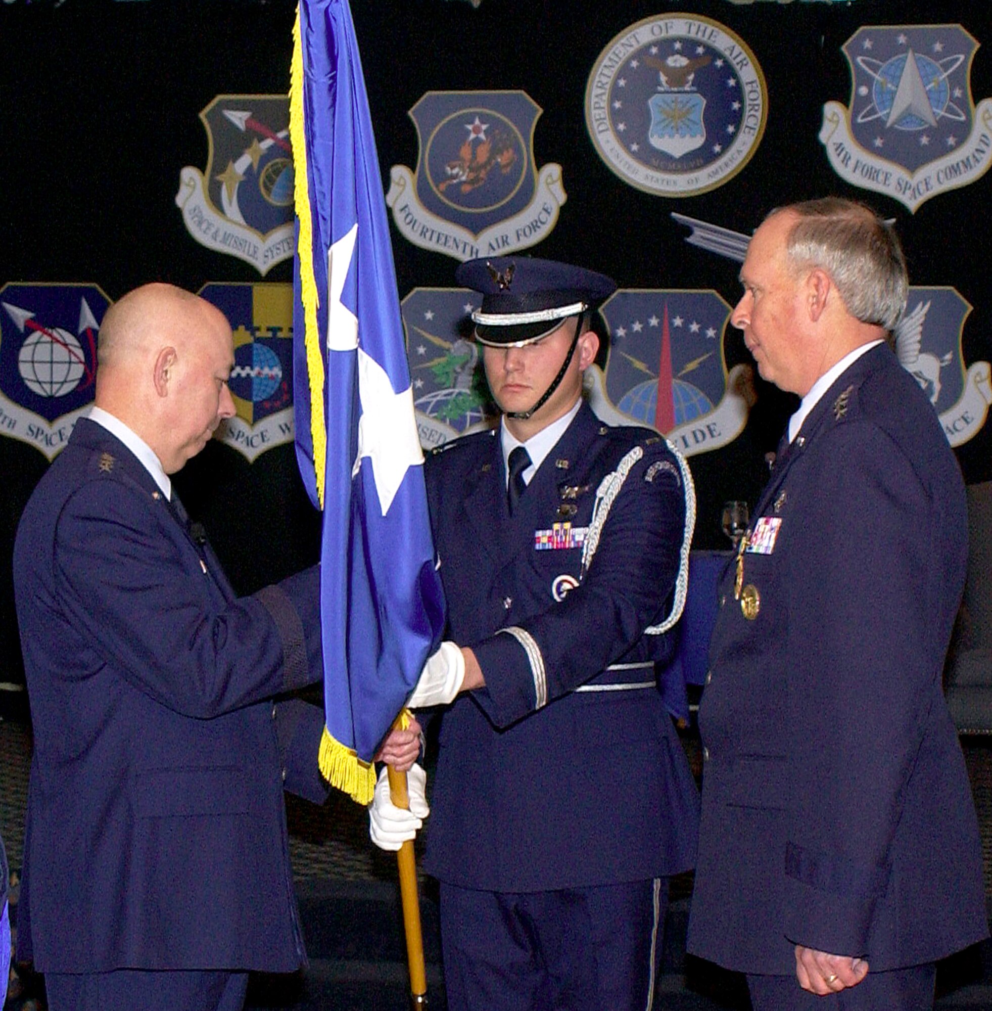 Air Force Chief of Staff Gen. T. Michael Moseley, left, prepares to hand the Air Force Space Command four-star flag of command to Gen. Lance W. Lord, right, during his retirement ceremony at Peterson Air Force Base, Colo., Friday, March 3, 2006. General Lord retired after a 37-year Air Force career. (U.S. Air Force photo) 