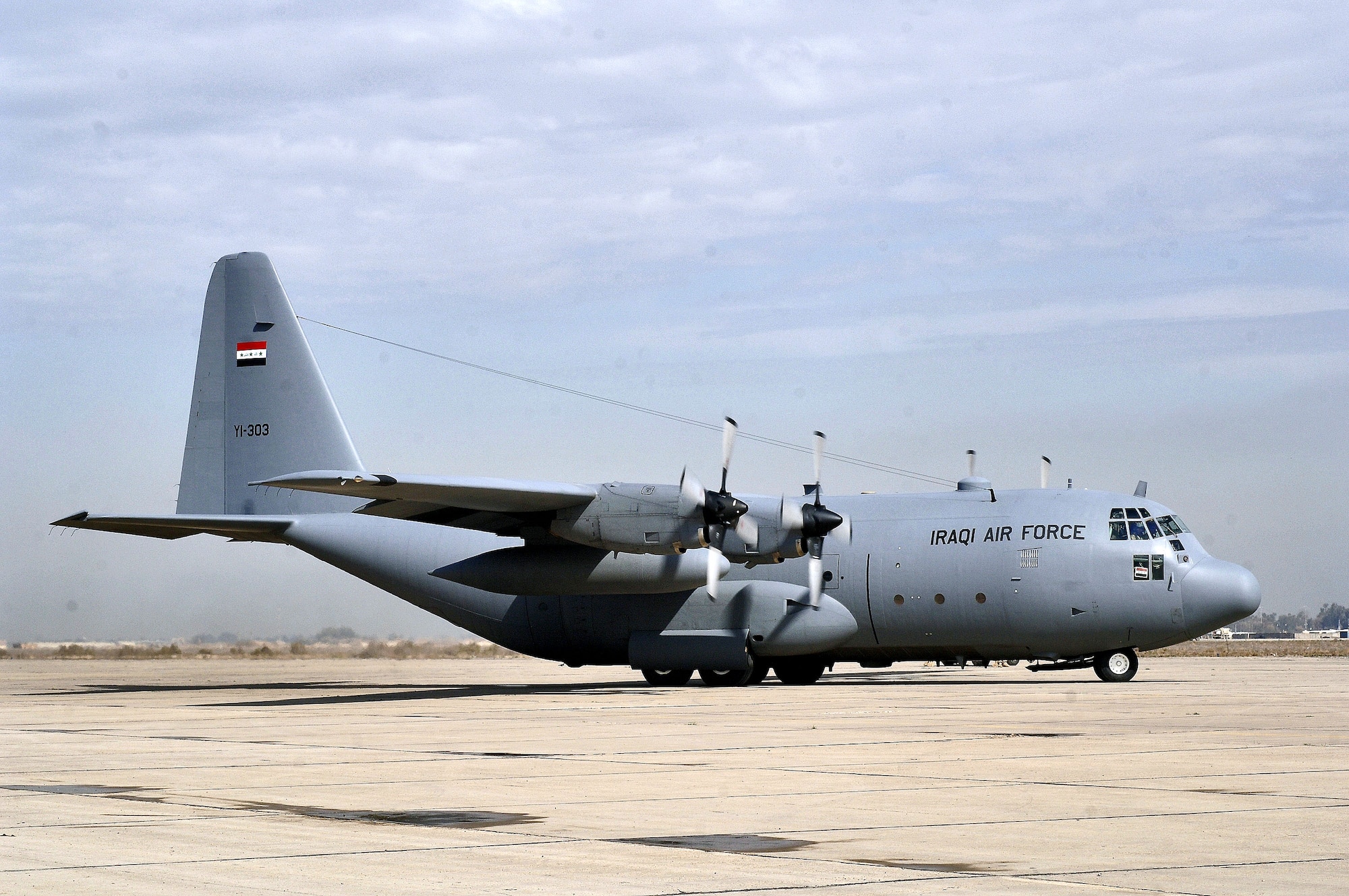 An Iraqi C-130 Hercules taxis onto the runway shared by Baghdad International Airport and New Al Muthana Air Base, Iraq, Wednesday, Feb. 22, 2006. The aircraft, YI-303, is one of three cargo aircraft at the new air base. (U.S. Air Force photo/Master Sgt. Lance Cheung) 