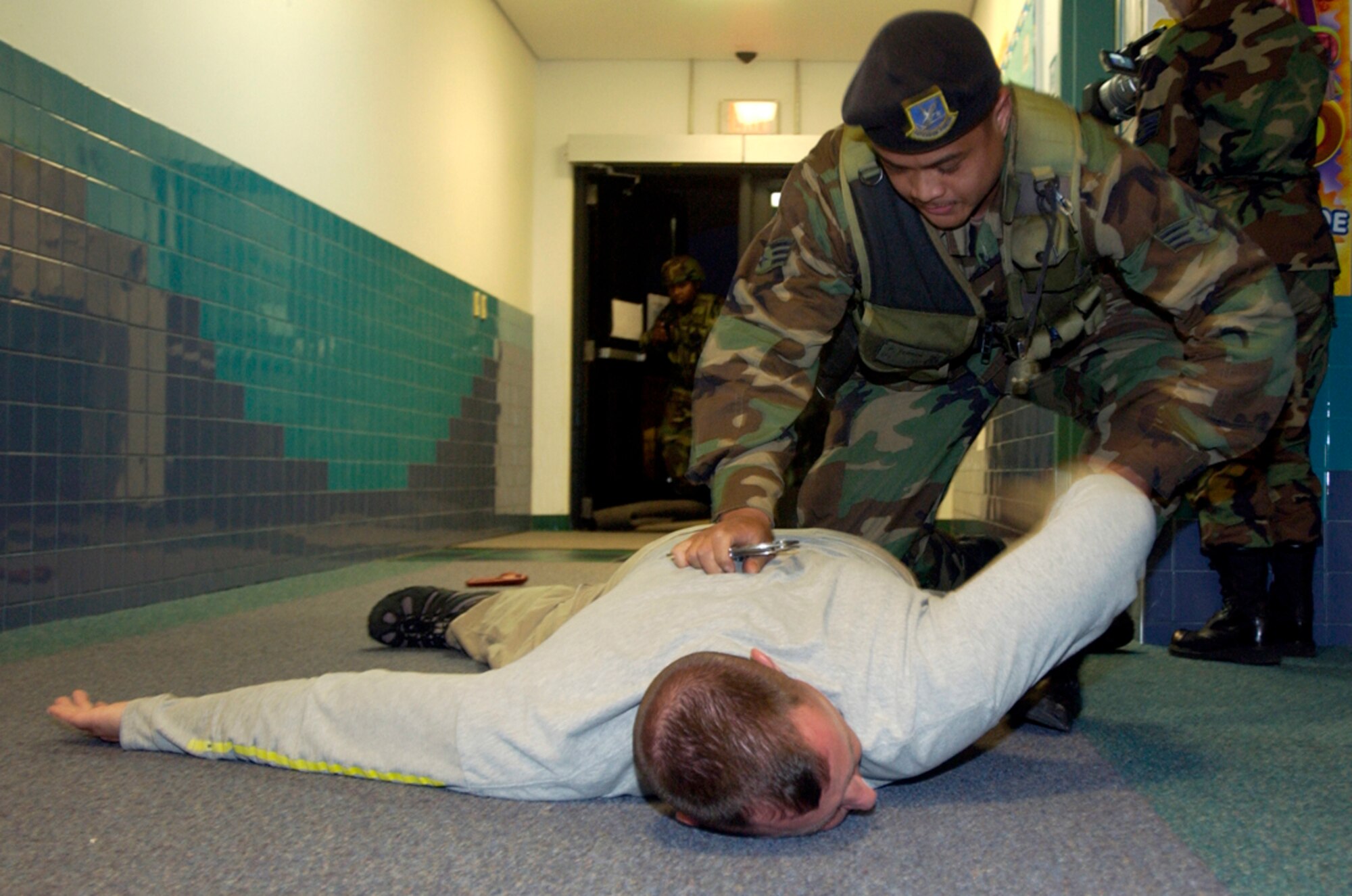 During a hostage negotiation exercise, Senior Airman Peter Ferrer detains a hostage taker after a three-hour stand-down with the 36th Security Forces Squadron Wednesday, Feb. 22, 2006, at Anderson Air Force Base, Guam. (U.S. Air Force photo/Airman Michael S. Dorus)

