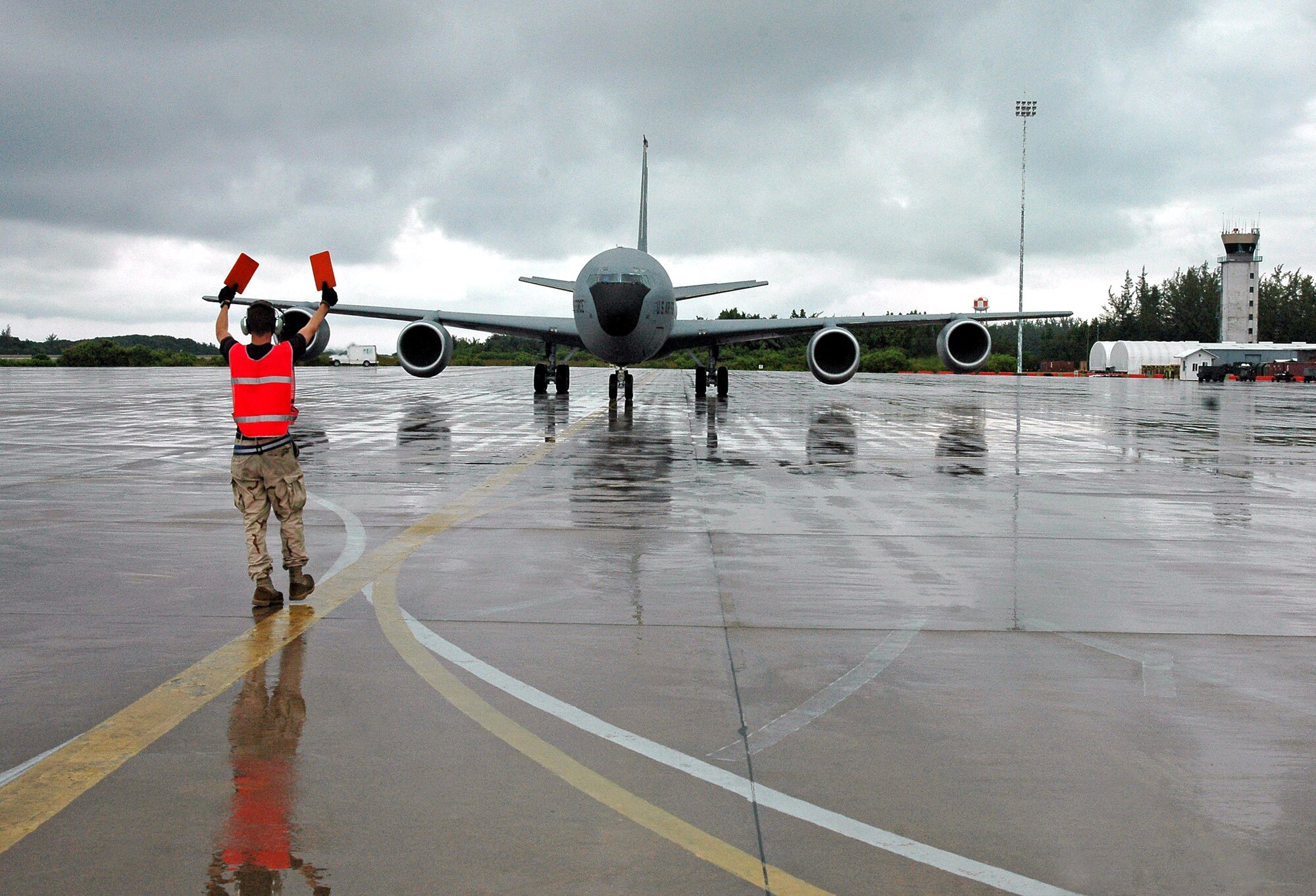 Senior Airman Tyler Main marshals a KC-135 Stratotanker to a position where it can then be towed into a parking position. Airman Main is a crew chief with the 28th Expeditionary Air Refueling Squadron. (U.S. Air Force photo/Staff Sgt. Doug Nicodemus)