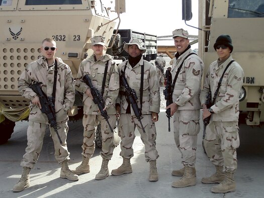 KIRTLAND AIR FORCE BASE, N.M. - From left to right: Senior Airman Ryan Barnes, Airman 1st Class Emma Hale, Airman 1st Class Christian Jackson, Technical Sgt. Johannes Eg and Senior Airman Robert Brown stand in front of Air Force gun trucks at a deployed location. The gun trucks are used to protect convoys during escort missions. (Courtesy photo)

