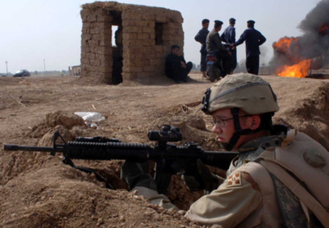 Army Pfc. Mark Hexum provides perimeter security during a reconnaissance patrol at the site of insurgent attack on an oil pipeline near Taji, Iraq, on March 1, 2006. Hexum is attached to the 66th Armored Battalion, 1st Brigade, 4th Infantry Division. 