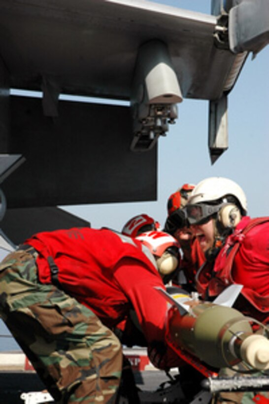 U.S. Navy aviation ordnancemen lift a laser-guided bomb to the bomb rack of an F/A-18E Super Hornet aircraft on the flight deck of the USS Ronald Reagan (CVN 76) as the aircraft carrier operates in the Persian Gulf on Feb. 28, 2006. Reagan and its embarked Carrier Air Wing 14 are conducting maritime security operations in the Persian Gulf region. 