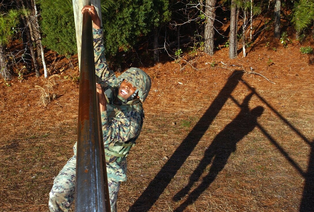 MARINE CORPS BASE CAMP LEJEUNE, N.C. - Cpl. Terence D. Hardy, a M1A1 tank crewman with Company B, 2nd Tank Battalion, 2nd Marine Division, struggles to maneuver through the obstacle course during his fifth consecutive trip. As part of a four-hour long evaluation known as the final drill, the obstacle course is just one of the many events that tests students of the Marine Corps Martial Arts Instructor Course on all the skills they've learned throughout the duration of the course.