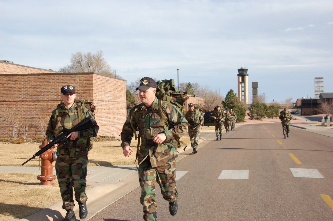PETERSON AIR FORCE BASE, Colo. (AFRC) - Members of the 302nd Logistics Readiness Squadron, 302nd Airlift Wing, take a different approach to War Fit program.  2nd Lt. F Schnell runs to take the lead of a squad of Airmen on a walk across the base carrying ruck sacks and M-16s while wearing personal body armor.  (U.S. Air Force photo by 2nd Lt. Jody Ritchie)
