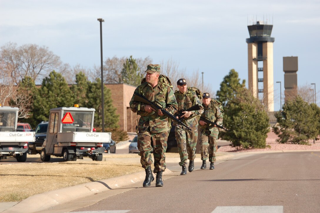 PETERSON AIR FORCE BASE, Colo. (AFRC) - Members of the 302nd Logistics Readiness Squadron, 302nd Airlift Wing, take a different approach to the War Fit program.  Senior Airman Steven Goodrich, Tech. Sgt. John Panos, and Tech. Sgt. Matthew Steele, go on a walk across the base carrying ruck sacks and M-16s while wearing personal body armor. (U.S. Air Force photo by 2nd Lt. Jody Ritchie) 