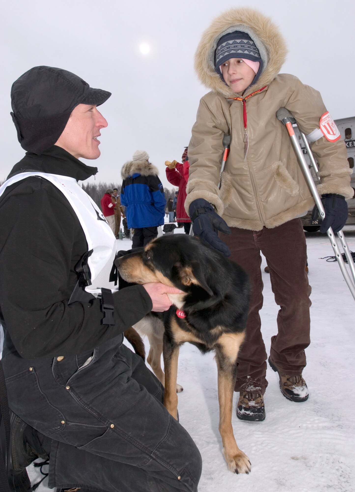 Maj. (Dr.) Thomas Knolmayer talks with 10-year-old Katie Powell before the start of the 2006 Iditarod Sled Dog Race. Katie is the daughter of Senior Master Sgt. Chris Powell of Travis Air Force Base, Calif., and is suffering from Ewing's Sarcoma, a rare bone cancer. (U.S. Air Force photo/Tech. Sgt. Keith Brown)