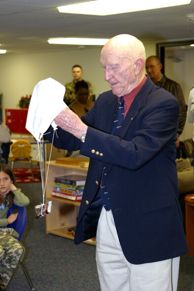 Retired Col. Gail S. Halvorsen, also known as the "Candy Bomber," shows children at the Pope Air Force Base, N.C., school age program how to make a parachute attached to a chocolate bar, much like those he dropped from his aircraft almost 60 years ago. He also signed copies of "Mercedes and the Chocolate Pilot," a book about a little girl living in Berlin during the Berlin Airlift.  (U.S. Air Force photo/Ed Drohan)