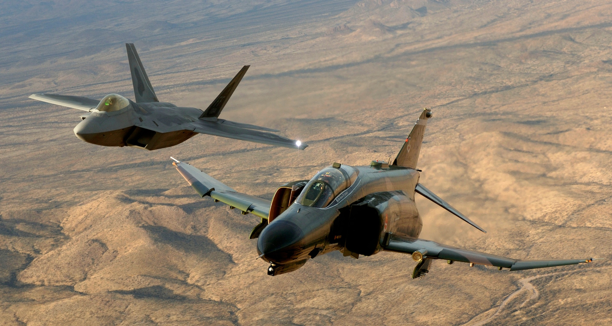 Lt. Col. Charles Hainline, an F-4 Phantom pilot from Holloman Air Force Base, N.M., and Lt. Col. Michael Shower, an F-22A Raptor pilot from Langley Air Force Base, Va., fly in formation over Tucson, Ariz., during the Air Combat Command Heritage Conference at Davis-Monthan Air Force Base Sunday, March 5, 2006.  (U.S. Air Force photo/Tech. Sgt. Ben Bloker)