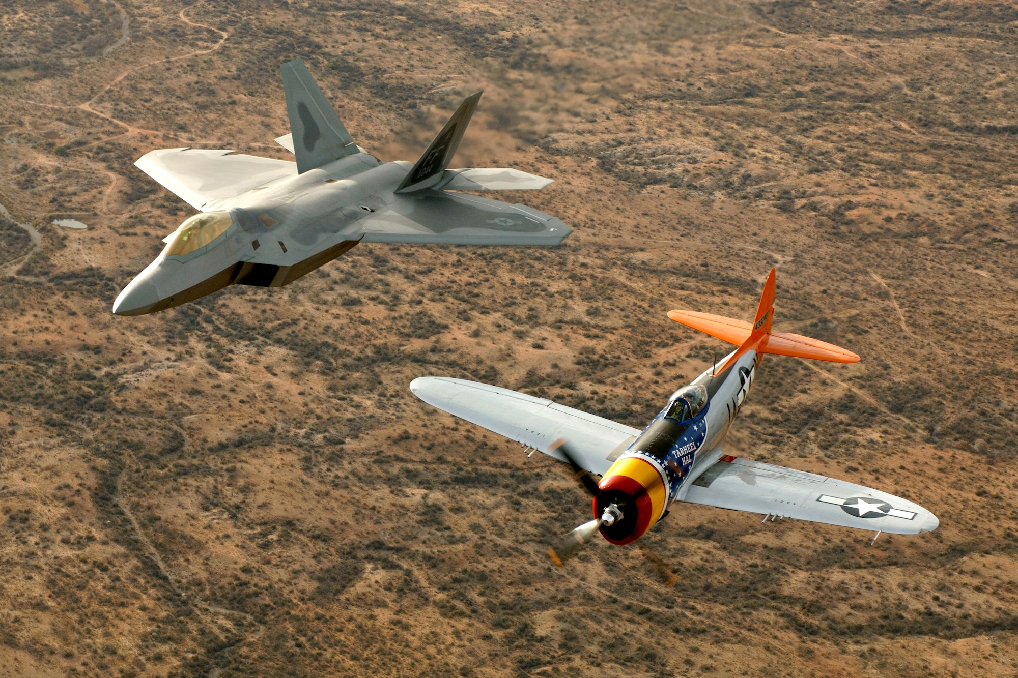A World War II-era P-47 Thunderbolt and an F-22A Raptor from Langley Air Force Base, Va., fly in formation over Tucson, Ariz., Sunday, March 5, 2006, during the Air Combat Command Heritage Conference at Davis-Monthan Air Force Base. Tom Gregory flew the Thunderbolt and Lt. Col. Michael Shower flew the Raptor. (U.S. Air Force photo/Tech. Sgt. Ben Bloker)

